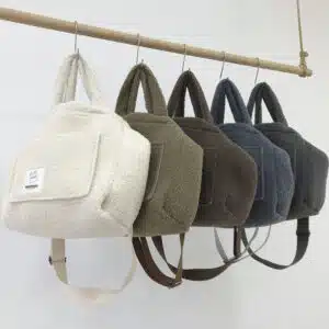 Collection de sac à main en fausse fourrure d'agneau pour femmes accrochée à une barre en bois