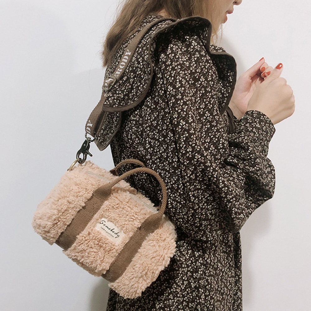 Petit sac à main de luxe imitation laine d'agneau rose porté par une femme de mode