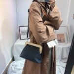 Femme qui porte un sac à bandoulière avec clip en bois design styliste noir