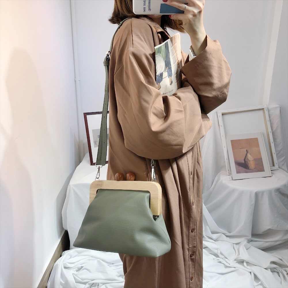 Femme qui porte un sac à bandoulière avec clip en bois design styliste vert