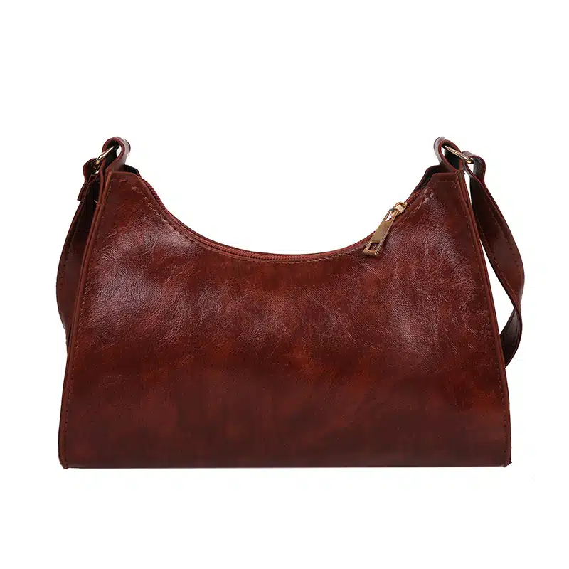 Petit sac à main marron façon cuir sur un fond blanc.