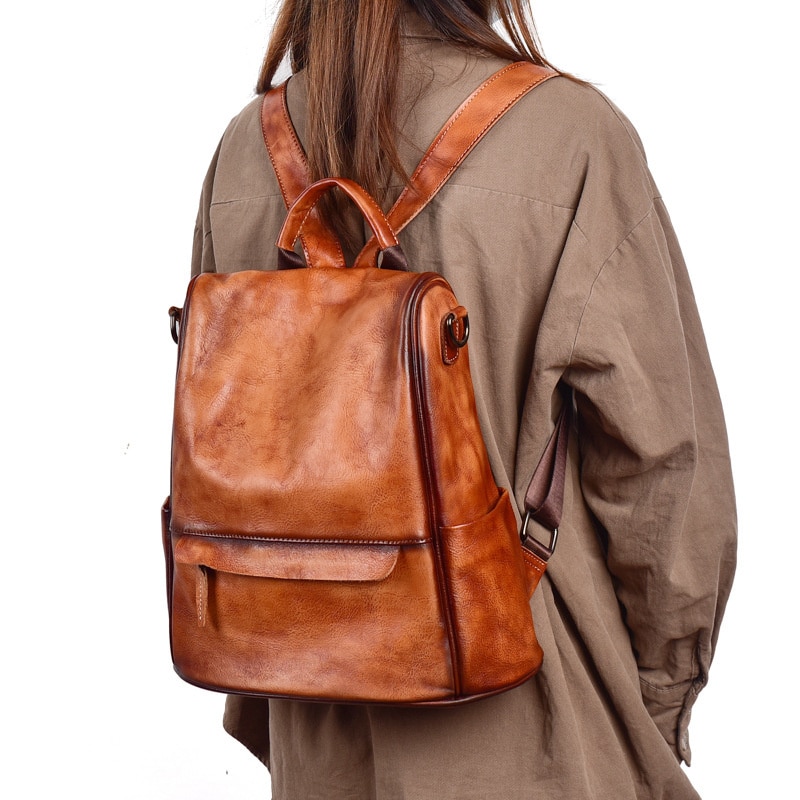 Petit sac de voyage vintage en cuir luxueux porté par une femme.