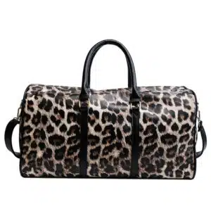 Un sac de voyage a bandoulière pour femme avec un imprimé de léopard. Il a deux hanses sur le dessus et une bandoulière à l'arrière.