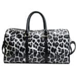 Un sac de voyage a bandoulière pour femme avec un imprimé de léopard gris. Il a deux hanses sur le dessus et une bandoulière à l'arrière.