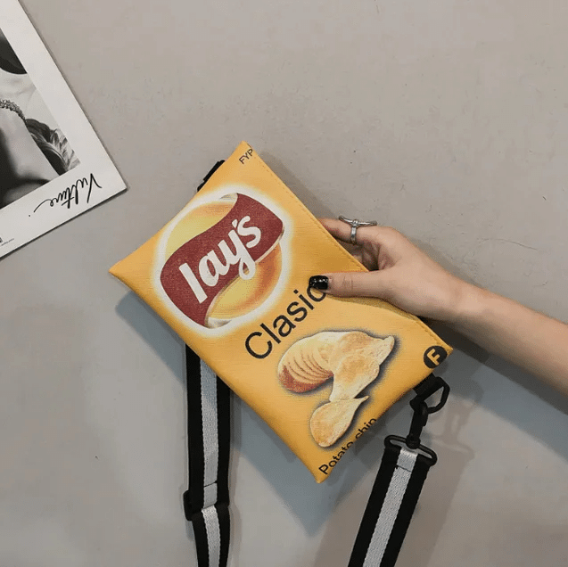 Pochette Banane au Design de Paquet de Chips dans la main d'une femme sur fond gris